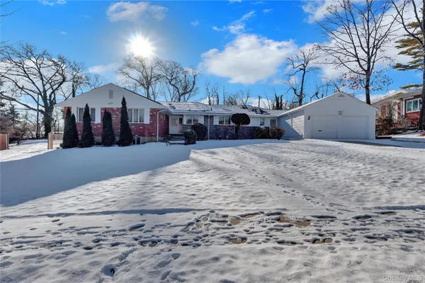 a view of a white house with a yard covered in snow