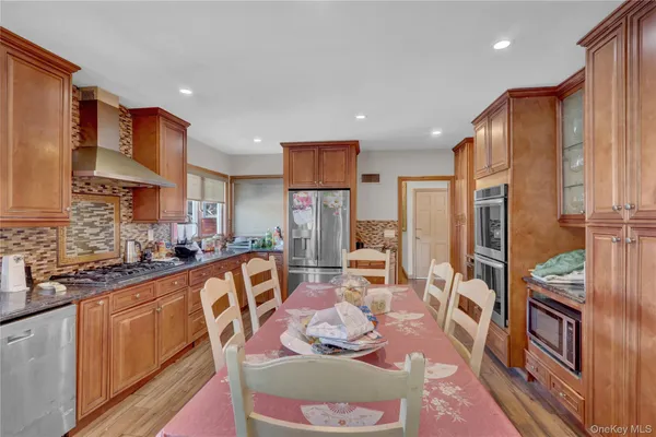 a kitchen with stainless steel appliances granite countertop sink stove refrigerator and cabinets