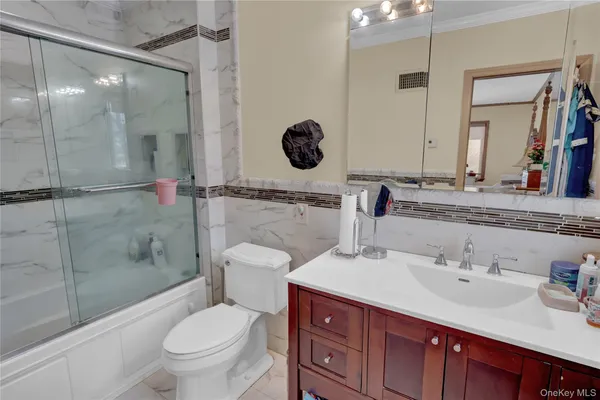a bathroom with a sink toilet vanity and shower