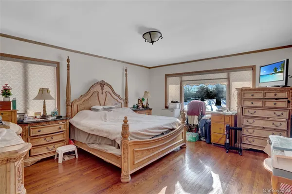 a bedroom with a bed and large windows