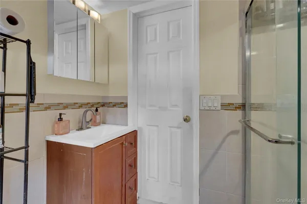 a bathroom with a sink vanity granite tub shower and mirror