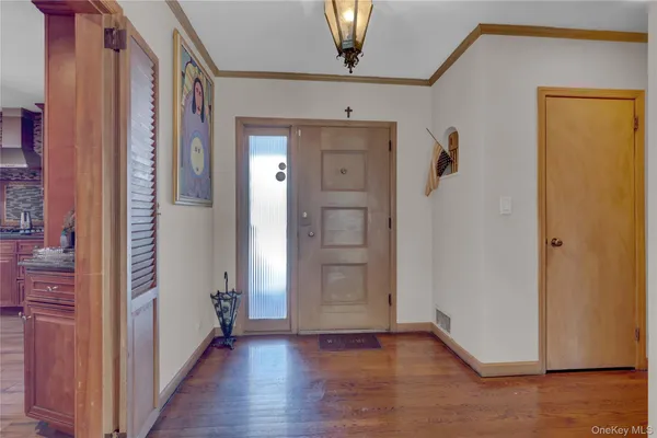 a view of a hallway with wooden floor and closet area