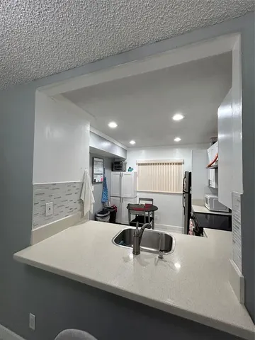 a large kitchen with a large counter top stainless steel appliances and cabinets