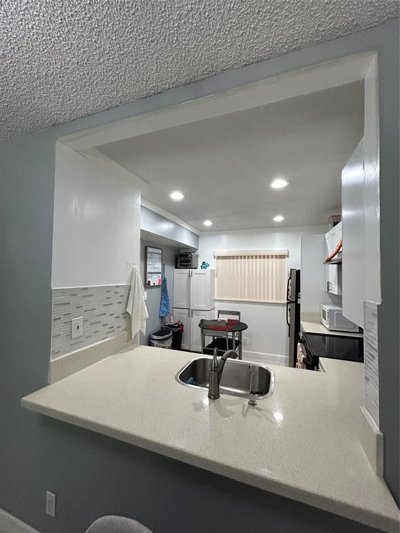 8818 West McNab Road, Unit 303 Tamarac, FL 33321 - Photo 12 of 23 a large kitchen with a large counter top stainless steel appliances and cabinets