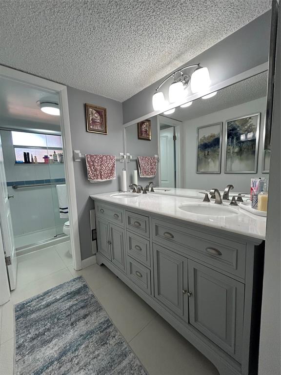 8818 West McNab Road, Unit 303 Tamarac, FL 33321 - Photo 16 of 23 a bathroom with a double vanity sink and a mirror