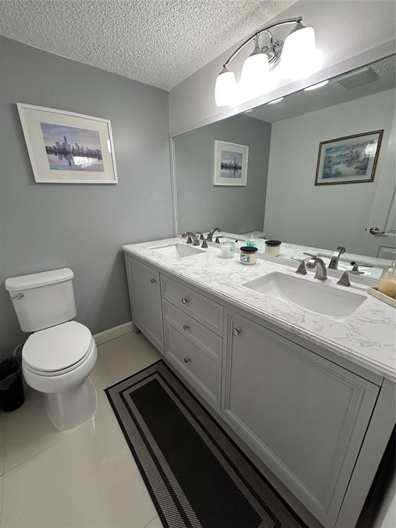 8818 West McNab Road, Unit 303 Tamarac, FL 33321 - Photo 19 of 23 a spacious bathroom with a toilet a sink and mirror