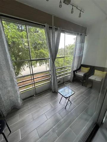 a living room with furniture and a floor to ceiling window