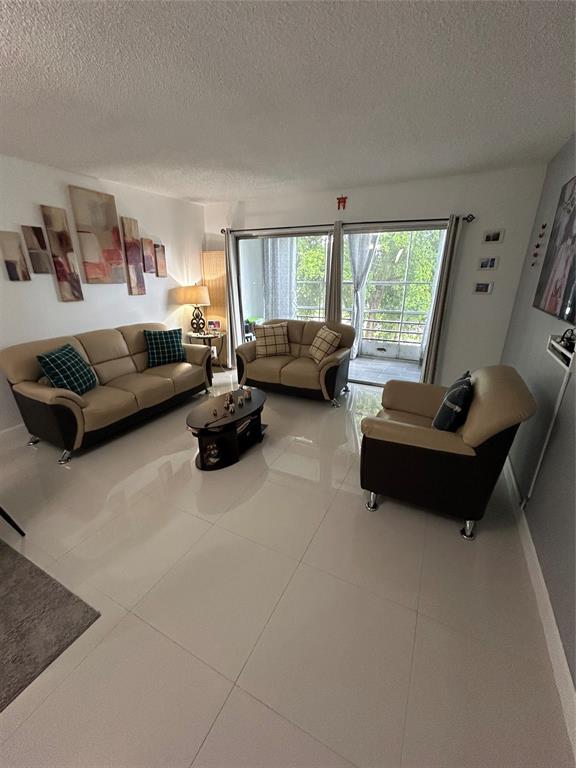 8818 West McNab Road, Unit 303 Tamarac, FL 33321 - Photo 4 of 23 a living room with furniture and a large window