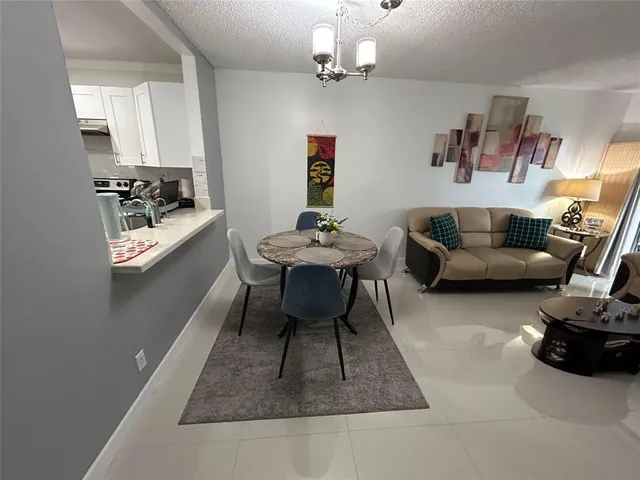 a living room with furniture and a dining table with kitchen view