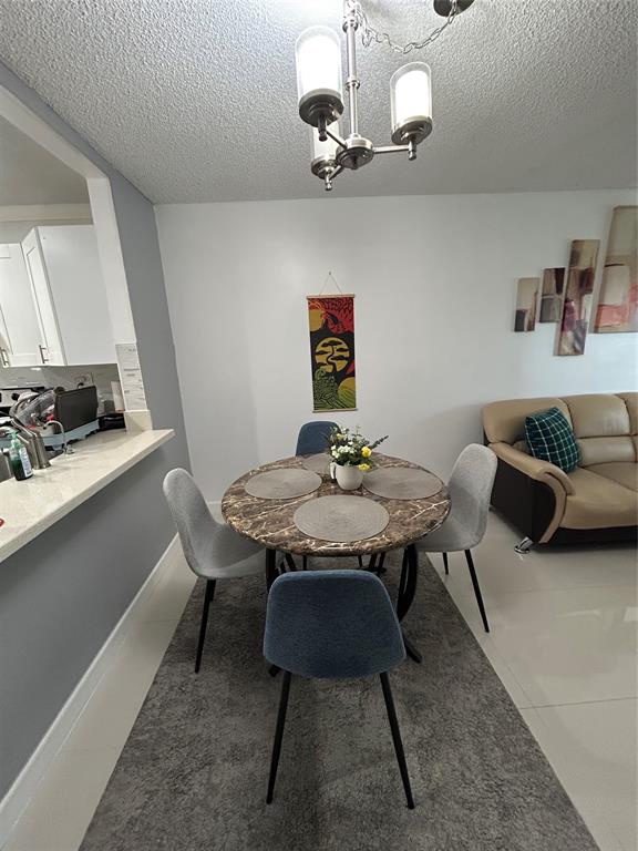 8818 West McNab Road, Unit 303 Tamarac, FL 33321 - Photo 9 of 23 a view of a dining room with furniture and a chandelier