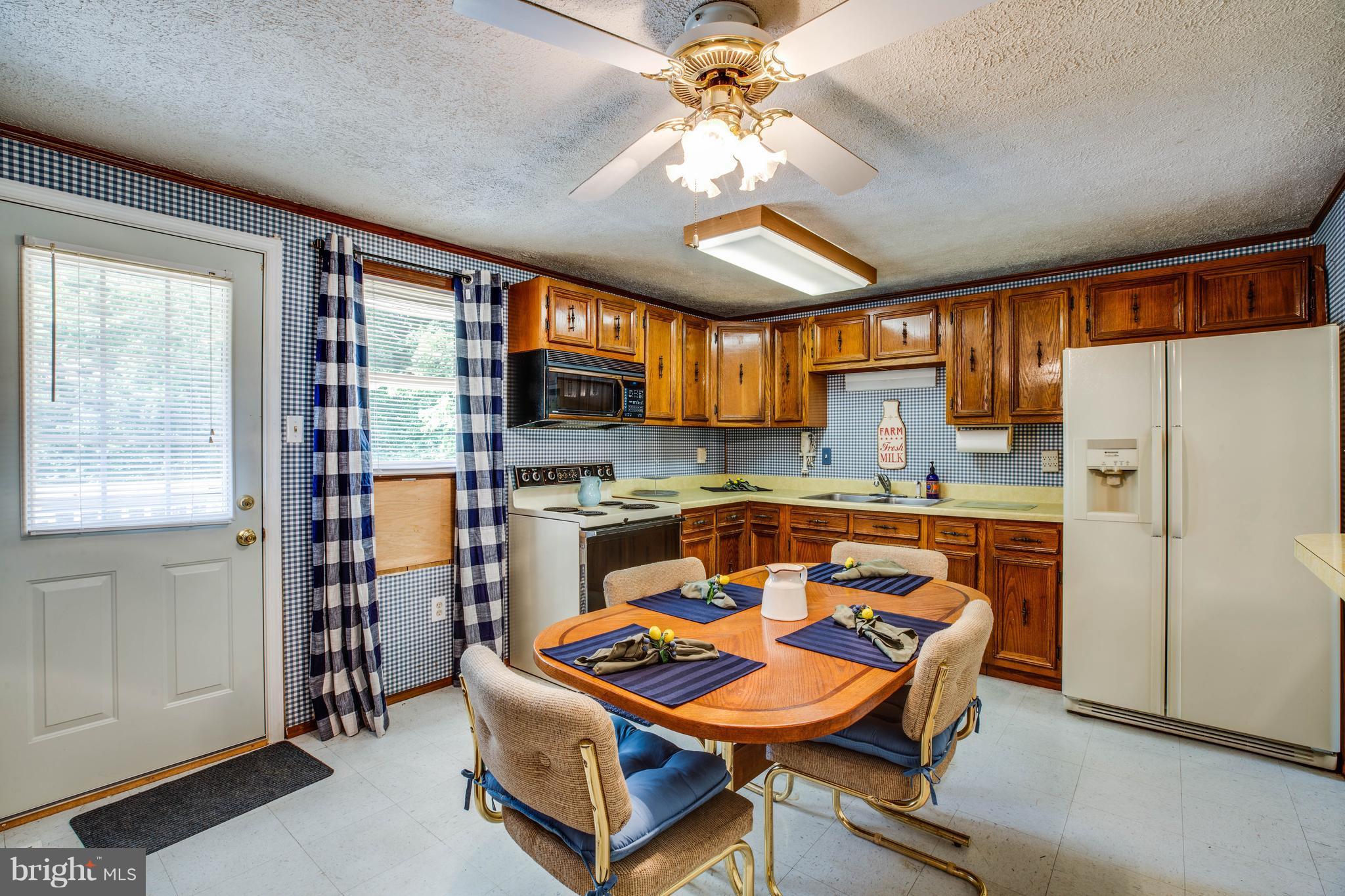 4314 Shepherds Road Partlow, VA 22534 - Photo 10 of 30 a kitchen with a refrigerator a sink and dishwasher with a dining table
