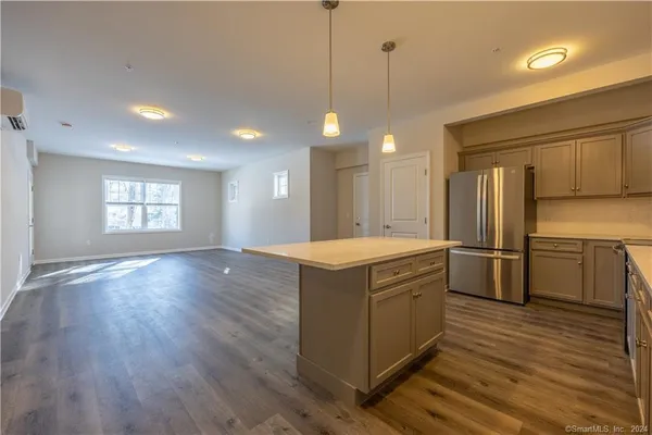 a kitchen with a refrigerator a sink and wooden floor