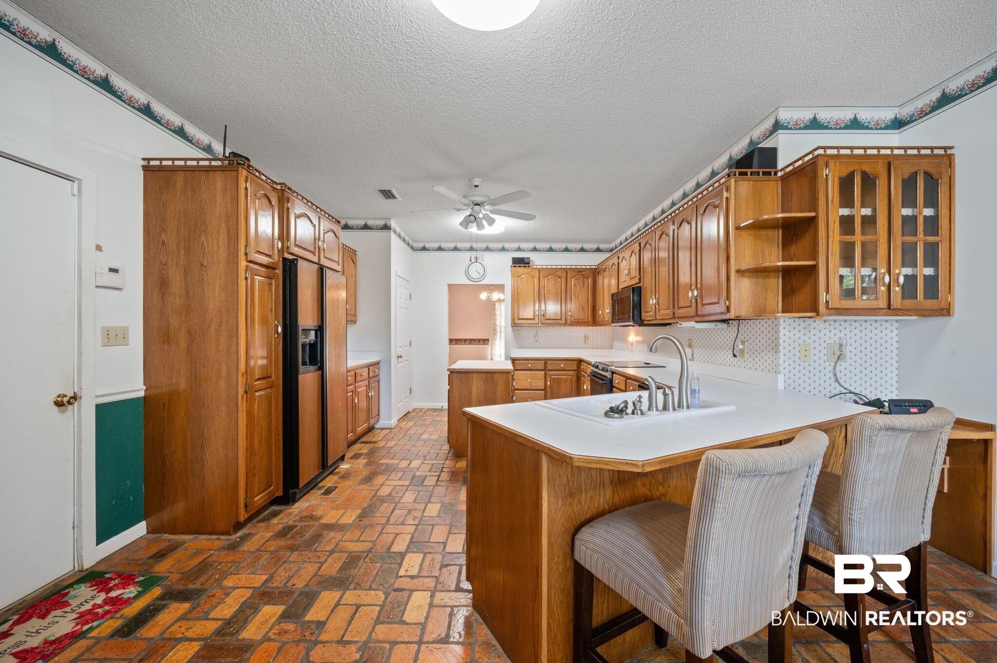 15801 Maytower Road Bay Minette, AL 36507 - Photo 18 of 43 Kitchen featuring a breakfast bar area, kitchen peninsula, sink, and a textured ceiling