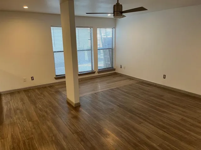 an empty room with wooden floor and a bathroom