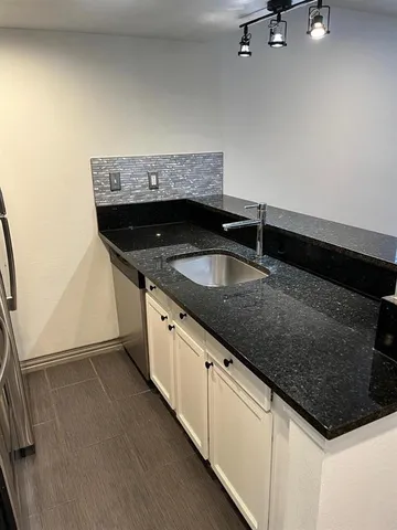 a kitchen with stainless steel appliances a stove a microwave and a sink