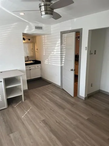a view of empty room with wooden floor and fireplace