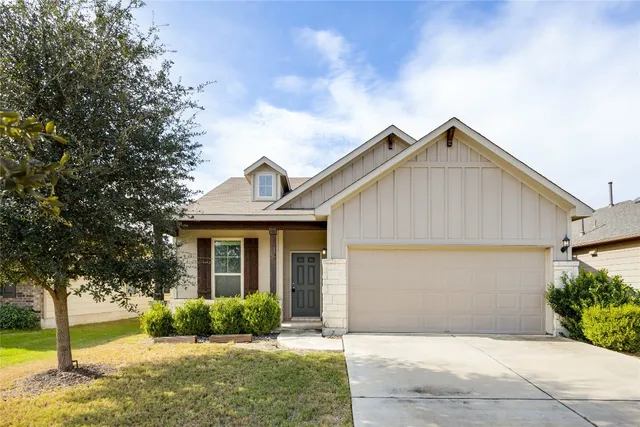 a front view of a house with a yard and potted plants