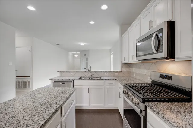 a kitchen with stainless steel appliances granite countertop a sink stove microwave and cabinets