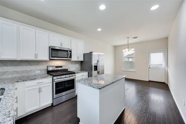 a kitchen with stainless steel appliances granite countertop a stove a sink and a refrigerator