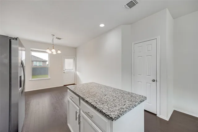 a view of kitchen island granite countertop cabinets and wooden floor