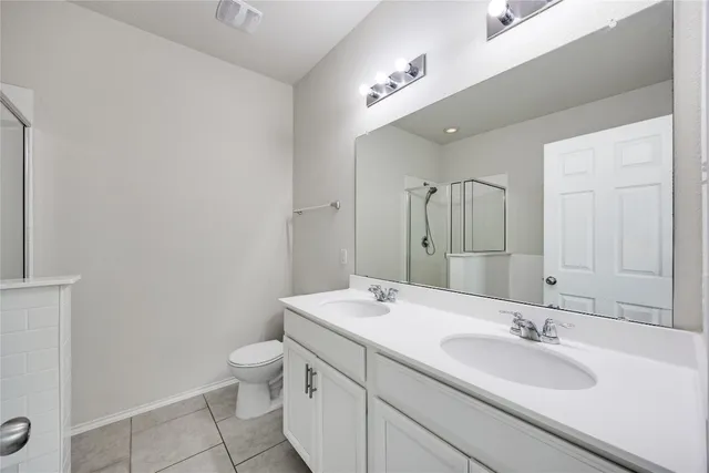 a bathroom with a sink a toilet and a large mirror