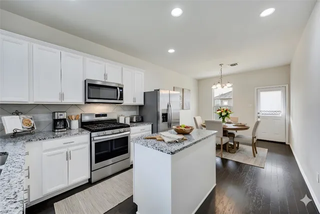 a kitchen with a sink stove and white cabinets