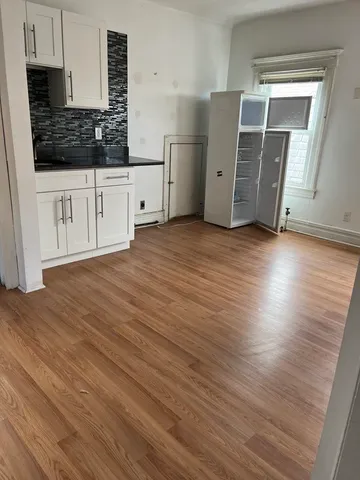 a kitchen with granite countertop white cabinets and wooden floor