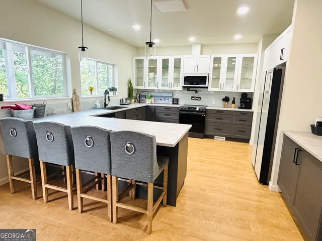 a kitchen with stainless steel appliances granite countertop a stove top oven a sink refrigerator and cabinets