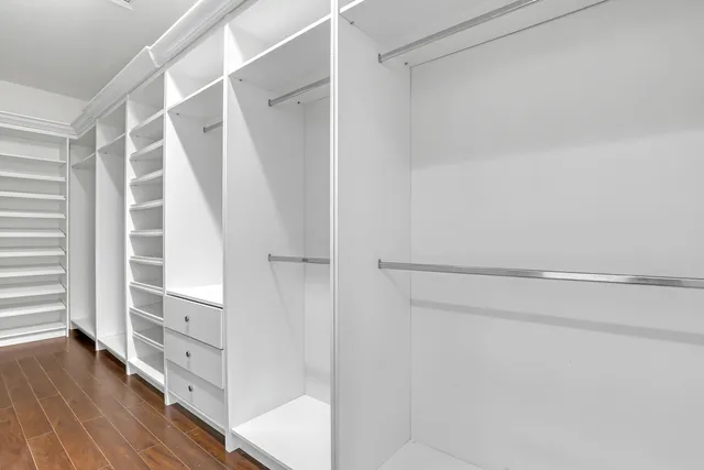 a view of walk in closet with empty racks