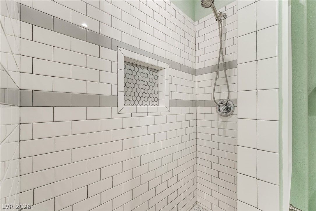261 Timber Hollow Street Henderson, NV 89012 - Photo 23 of 51 A well-appointed shower with subway tile, a recessed niche, and convenient handheld showerhead.