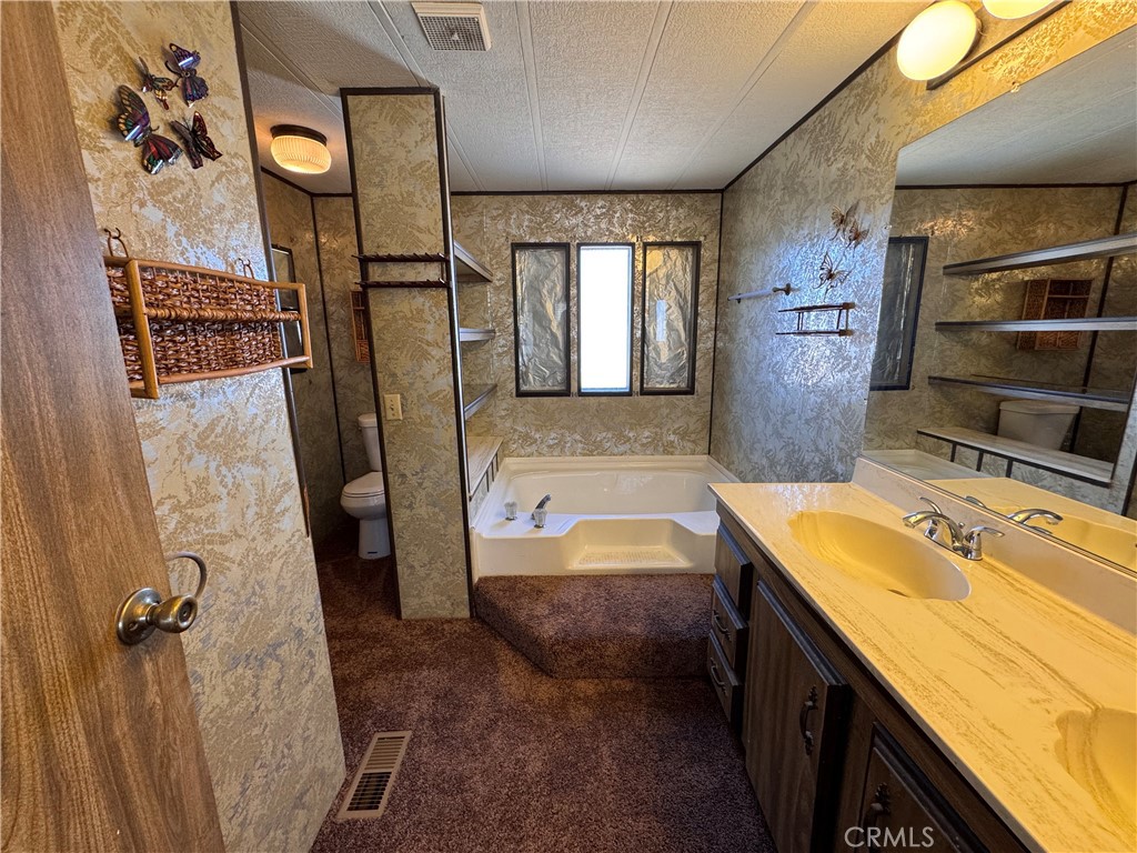 25544 Jasper Road Barstow, CA 92311 - Photo 23 of 62 a bathroom with a tub sink and mirror