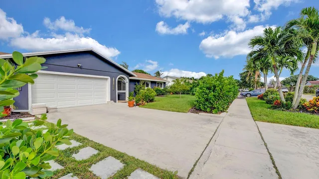 a yellow house with flower garden in front of it