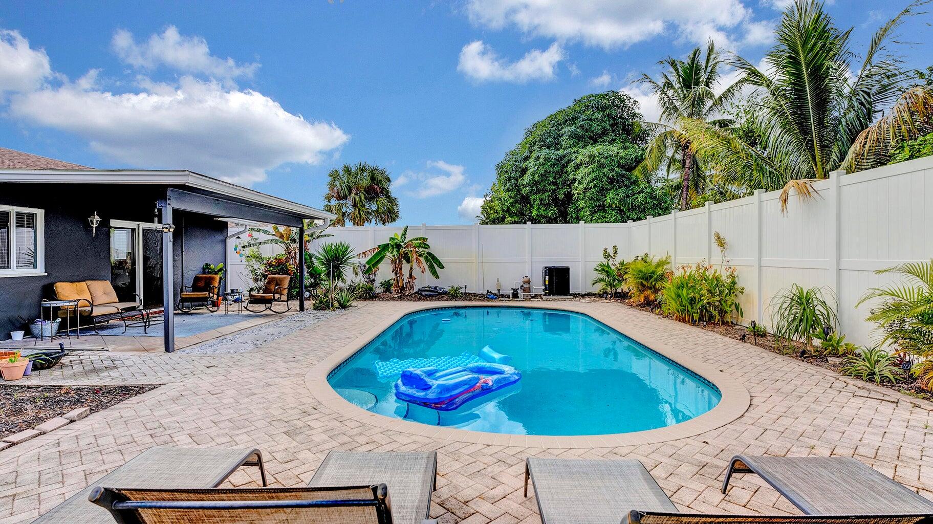 2941 Angler Drive Delray Beach, FL 33445 - Photo 22 of 34 a view of a swimming pool with potted plants