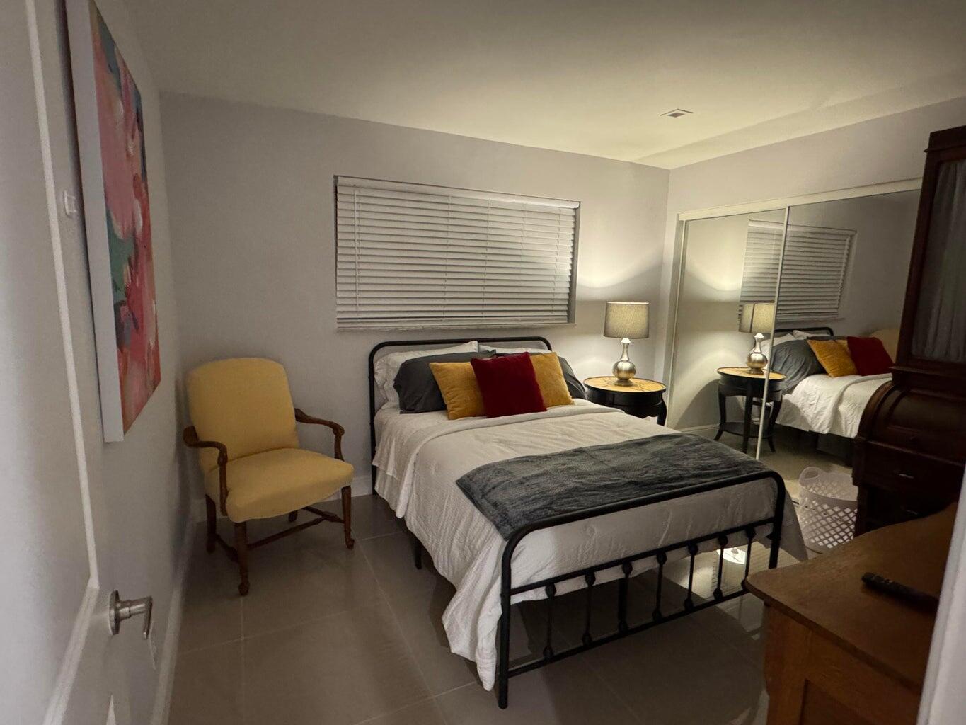 2941 Angler Drive Delray Beach, FL 33445 - Photo 29 of 34 a spacious bedroom with a bed and lamp