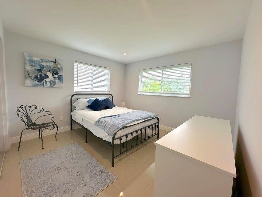 2941 Angler Drive Delray Beach, FL 33445 - Photo 30 of 34 a bedroom with a bed and a chair