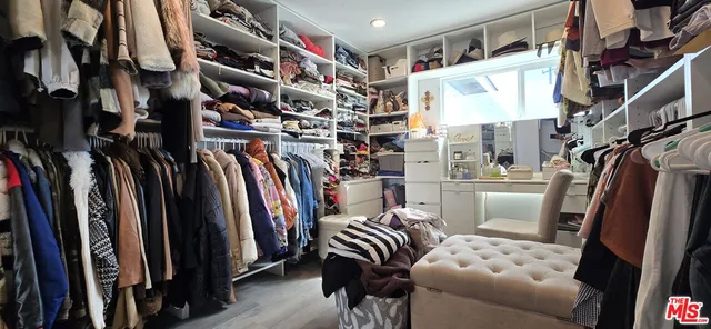 a bedroom with a bed a books bucket with a desk and chair