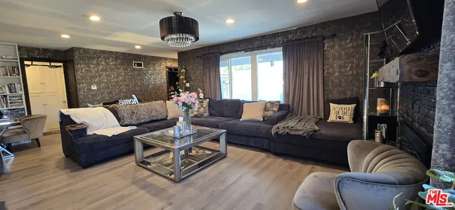a living room with furniture a fireplace and a view of kitchen