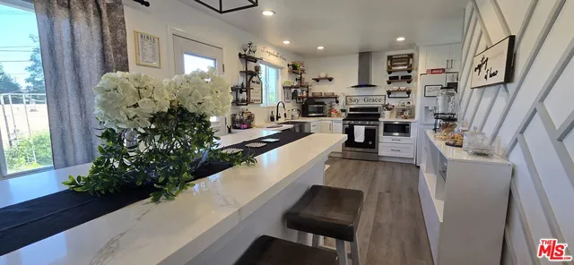 a kitchen with stainless steel appliances a stove top oven a sink and dishwasher with wooden floor