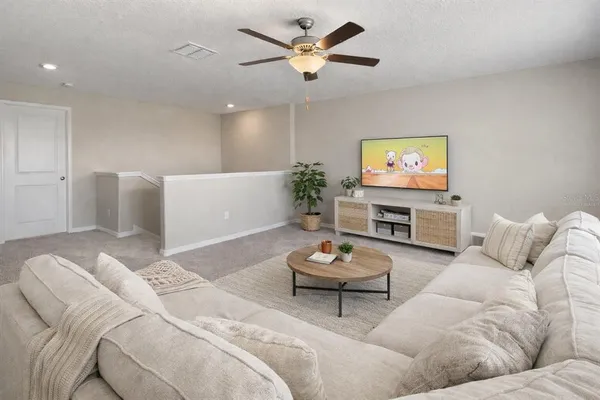 a living room with furniture a flat screen tv and a fireplace