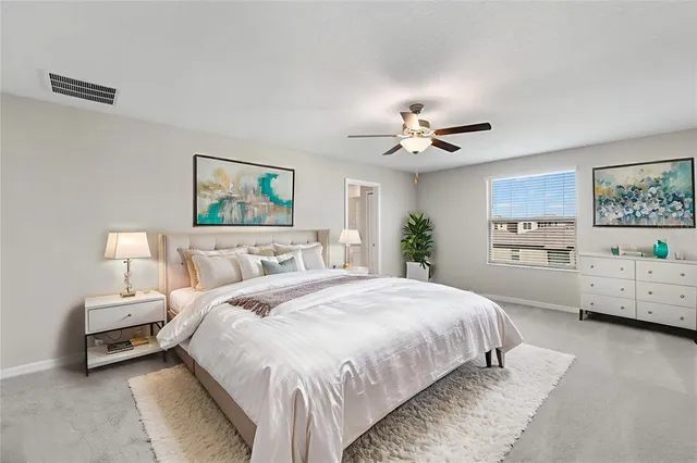 a spacious bedroom with a bed and a ceiling fan