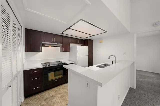 a kitchen with stainless steel appliances granite countertop a sink and a refrigerator