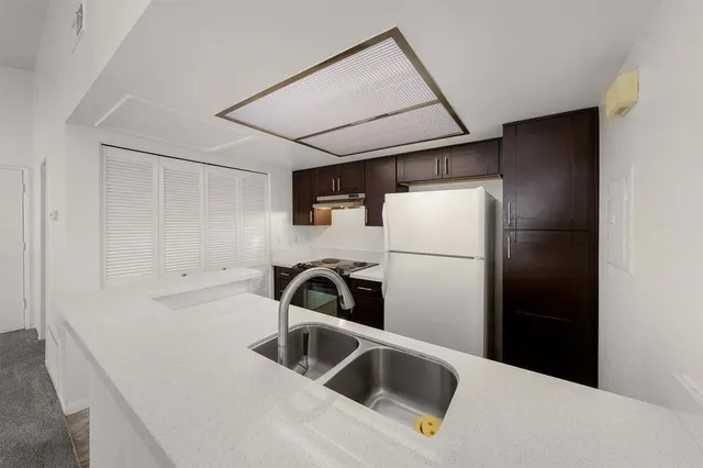 a kitchen with a refrigerator sink and cabinets