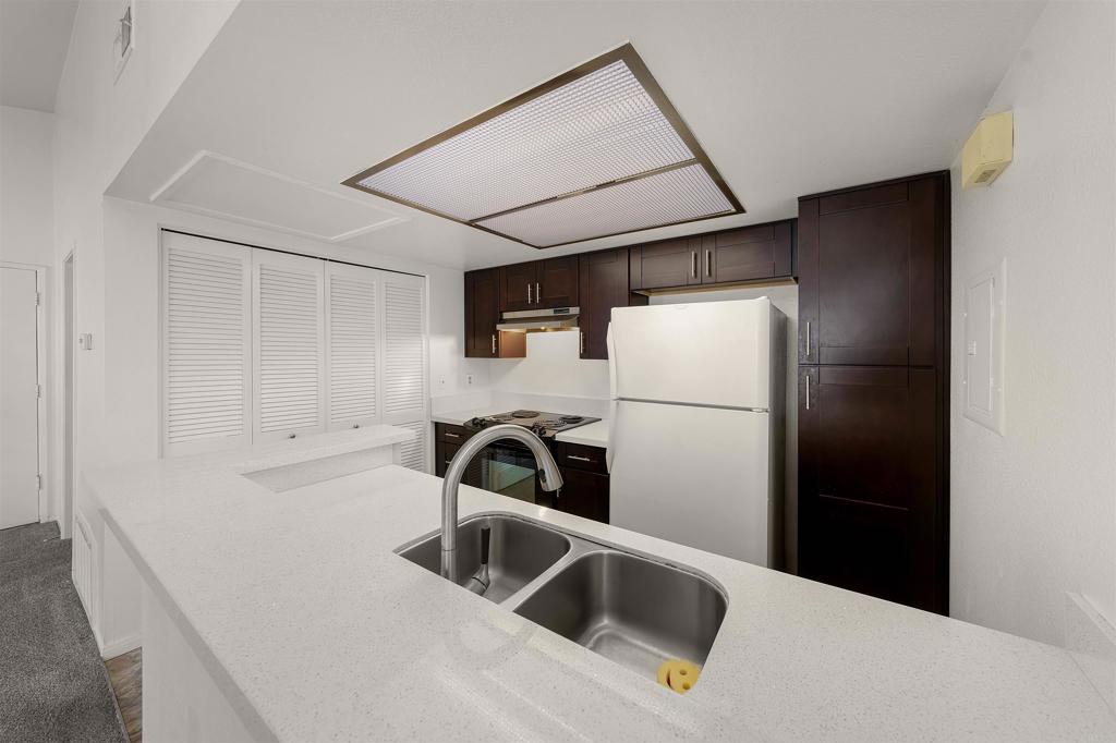 765 Eastshore Terrace, Unit 201 Chula Vista, CA 91913 - Photo 7 of 22 a kitchen with a refrigerator sink and cabinets