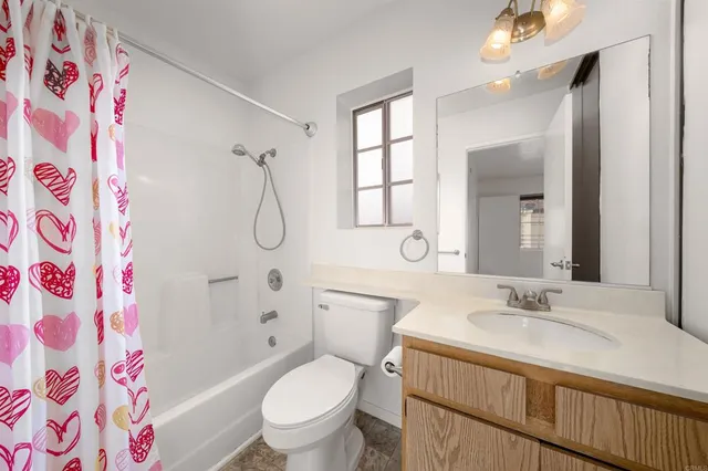 a bathroom with a granite countertop sink toilet a shower and a mirror