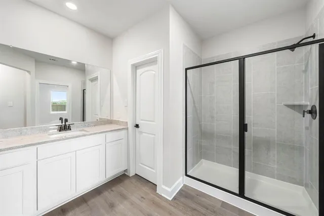 a en suite bathroom with a shower sink and mirror
