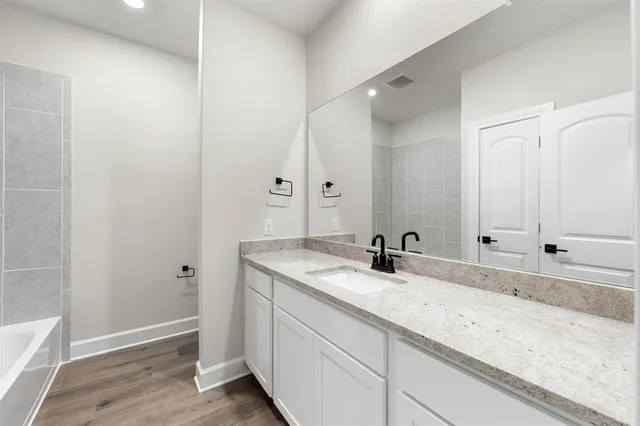 a bathroom with a granite countertop sink and a mirror