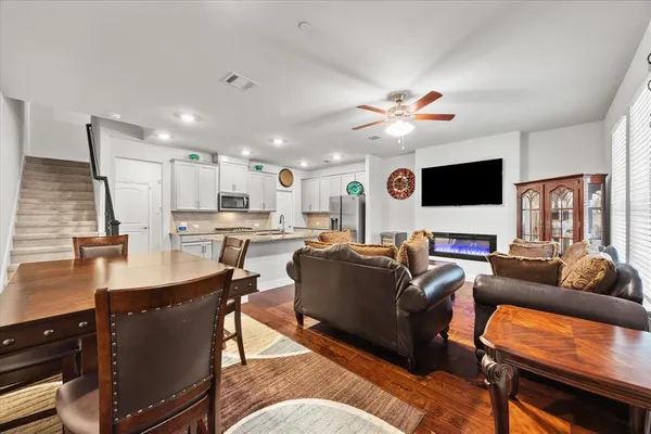 a living room with furniture kitchen view and a large window
