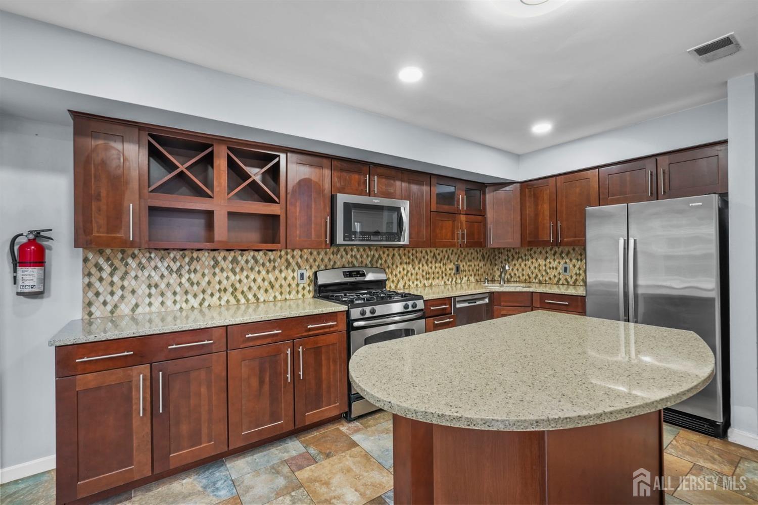 215 Nebula Road Piscataway, NJ 08854 - Photo 11 of 37 a kitchen with stainless steel appliances granite countertop a sink a microwave a refrigerator and a stove