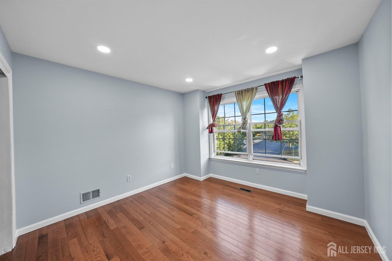 215 Nebula Road Piscataway, NJ 08854 - Photo 18 of 37 an empty room with wooden floor and windows