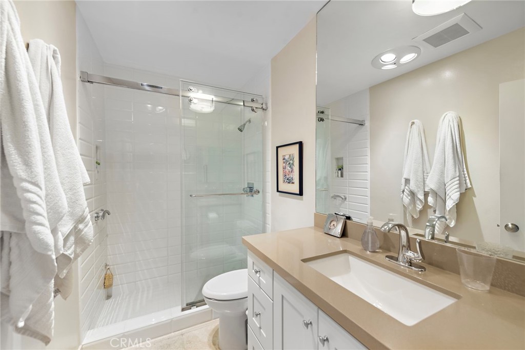 21703 Ocean Vista Drive, Unit 102 Laguna Beach, CA 92651 - Photo 17 of 19 a bathroom with a granite countertop sink toilet and shower
